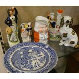 A Staffordshire spaniel together with three Staffordshire pieces, character jug and blue and white