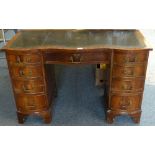 A mahogany serpentine kneehole desk, inset sciver, with four drawers to each side with a central