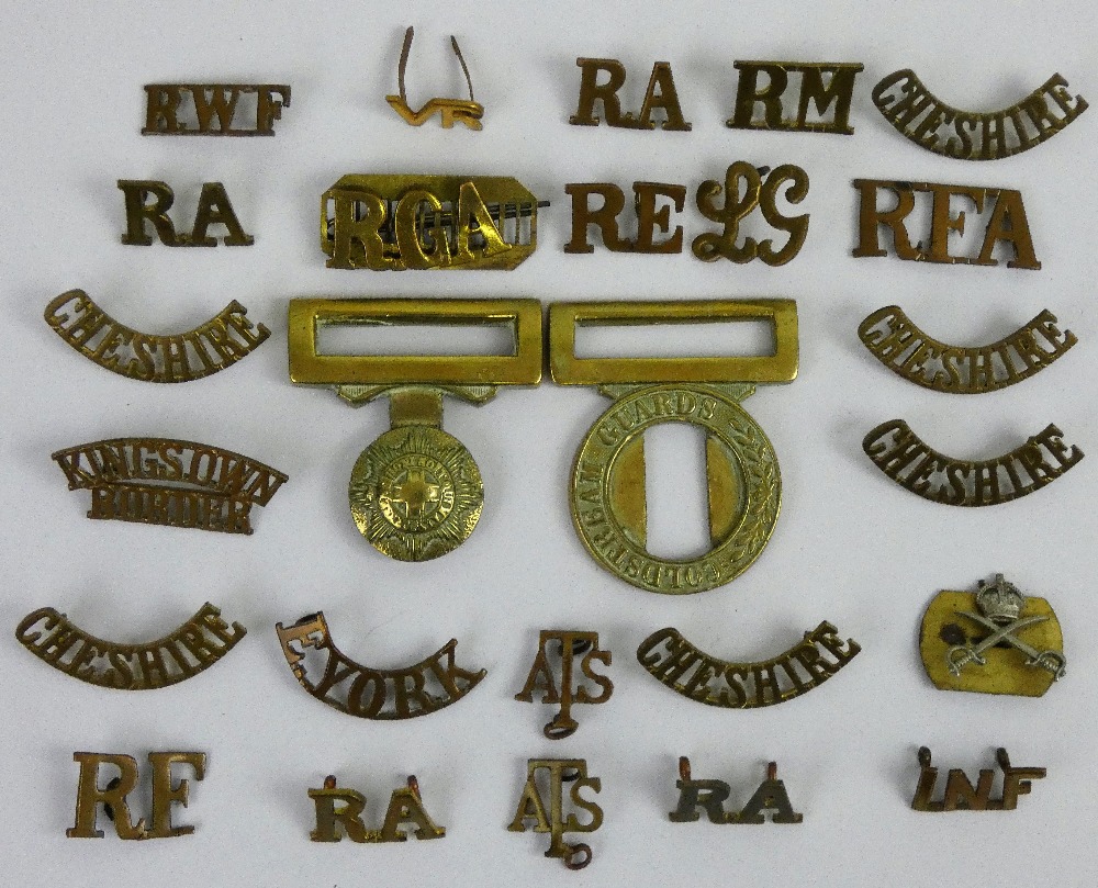 A collection of approximately 40 brass shoulder titles, together with a Coldsteam Guards belt