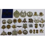 A collection of approximately 60 named British military badges, including GCR and RWAFF.