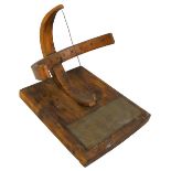 An equinoctial wooden sundial with a brass gnomon, on rectangular base with instructional plaque