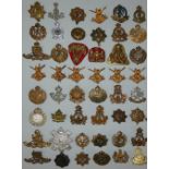 A collection of approximately 75 Kings Crown cap badges.