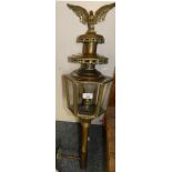 A brass carriage style lamp with brass eagle figure to top