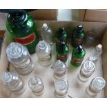 A collection of pharmaceutical bottles green and clear, the majority with labels