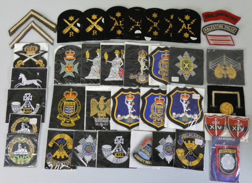 A collection of approximately 40 military cloth and blazer badges.