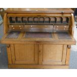 A barrel top bureau, the fitted interior of pigeon holes over three drawers with sliding top and