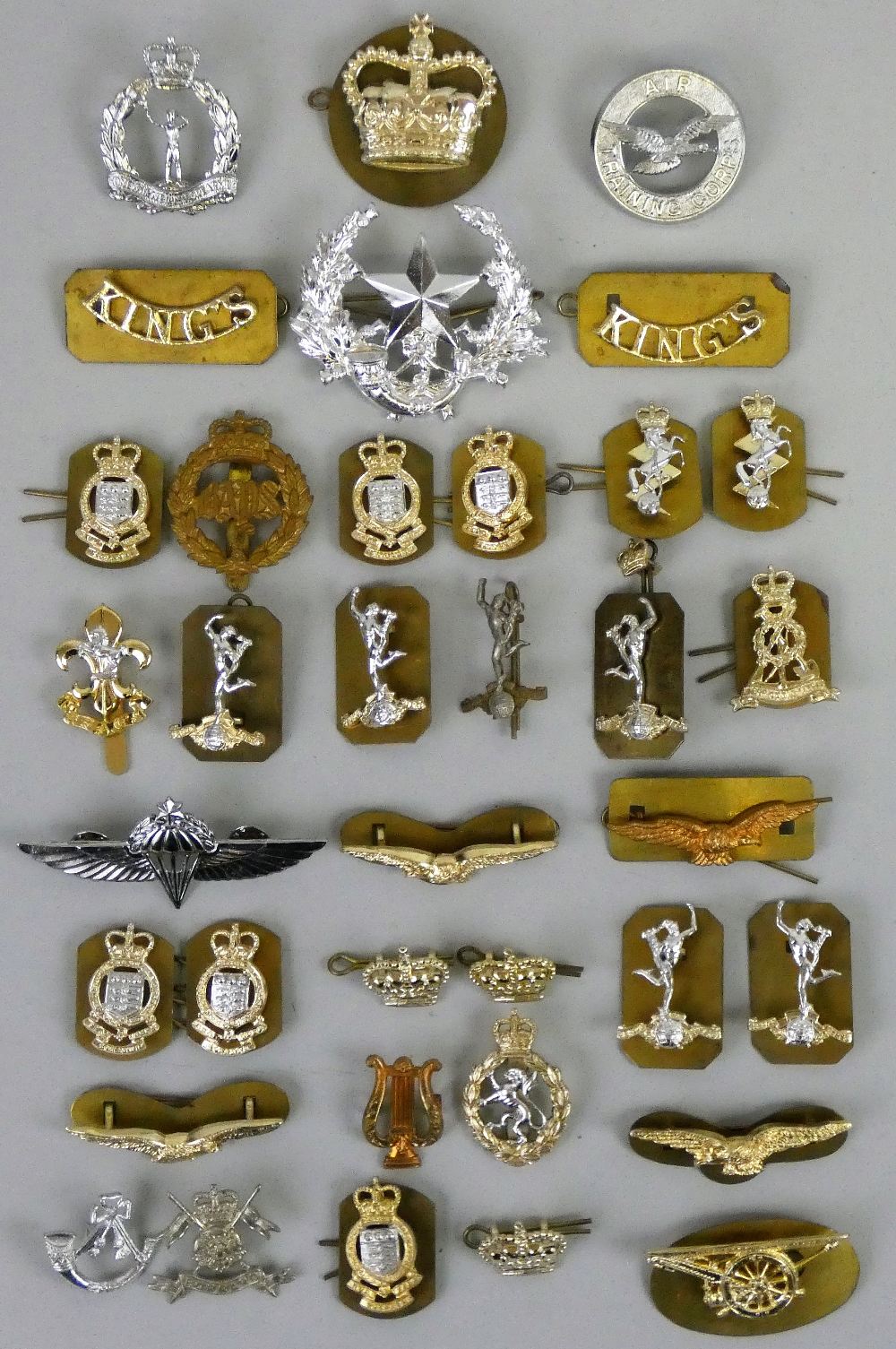 A collection of approximately 80 modern military cap and shoulder badges.