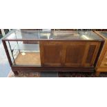 A shop display cabinet, 184 x 60 x 90 cm, glazed all around apart from the sliding rear doors to the