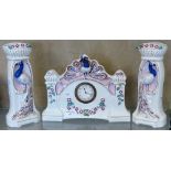 A Belgium clock garniture in white ceramic with peacock emblems