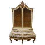A Spanish white painted china display cabinet, Valencia retailers label, the arch topped with carved