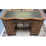A mahogany serpentine knee hole desk, inset scriber with four drawers to each side with a central