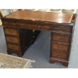 A mahogany knee hole desk, 121 cm x 62 cm, inset scriber and four drawers to each side and central