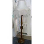An oak standard lamp with cream and pink frilled shade