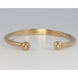 A 9ct yellow gold bangle with bead ends 21.2 grams