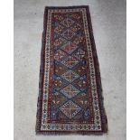 An Antique Caucasian runner with 7 diamonds to the centre within multi row borders 298cm x 111cm