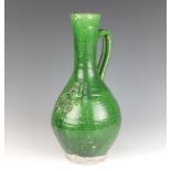 An 18th/19th century green slip glazed bulbous bodied ewer decorated with leaves 37cm