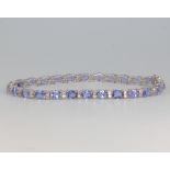 An 18ct white gold tanzanite and diamond line bracelet, the tanzanites approx. 9.2ct, diamonds