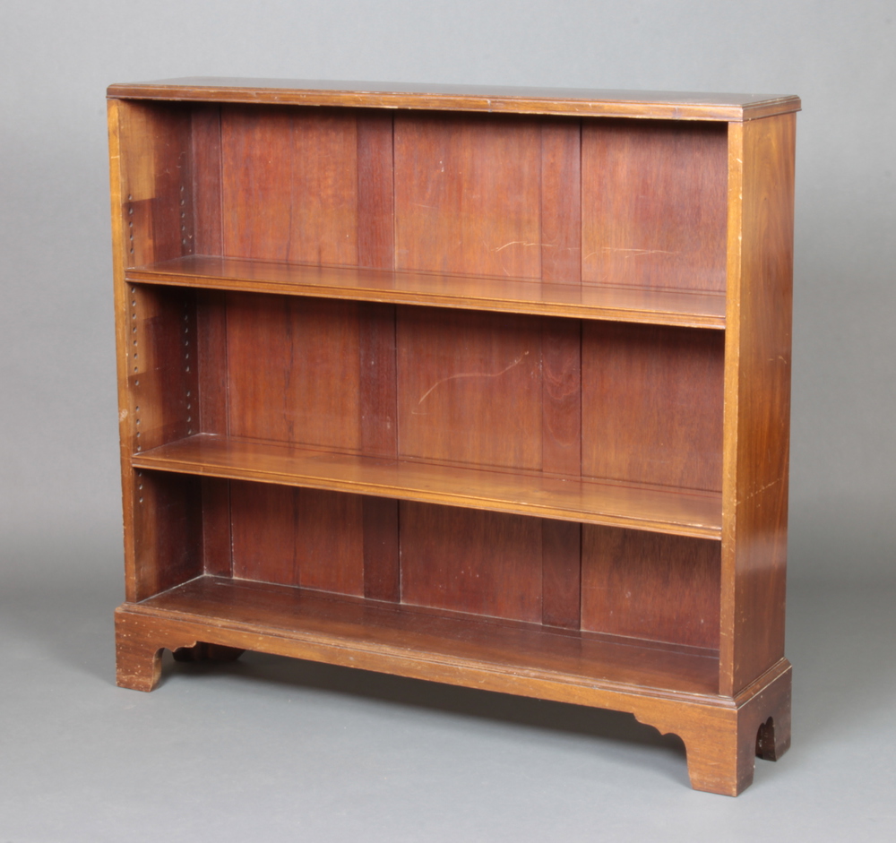 A walnut bookcase fitted adjustable shelves raised on bracket feet 103cm h x 111cm w x 24cm d