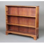 A walnut bookcase fitted adjustable shelves raised on bracket feet 103cm h x 111cm w x 24cm d