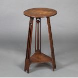 In the manner of Voisy, a circular Art Nouveau oak 2 tier occasional table/plant stand raised on 3