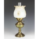 A brass oil lamp with clear glass chimney and an opaque glass shade
