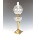 A Victorian cut glass and brass oil lamp with clear cut glass reservoir raised on a reeded brass