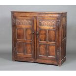 A 19th Century, 17th Century style carved oak cupboard enclosed by panelled doors, the top formed of