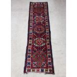 A blue and red ground Caucasian runner 330cm x 85cm Some flecking overall and the fringe has been