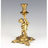 A gilt metal candlestick in the form of a cherub raised on a rococo style base 24cm x 11cm x 11cm (