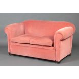 A Victorian drop arm Chesterfield upholstered in rose pink material, raised on bun feet 75cm h x