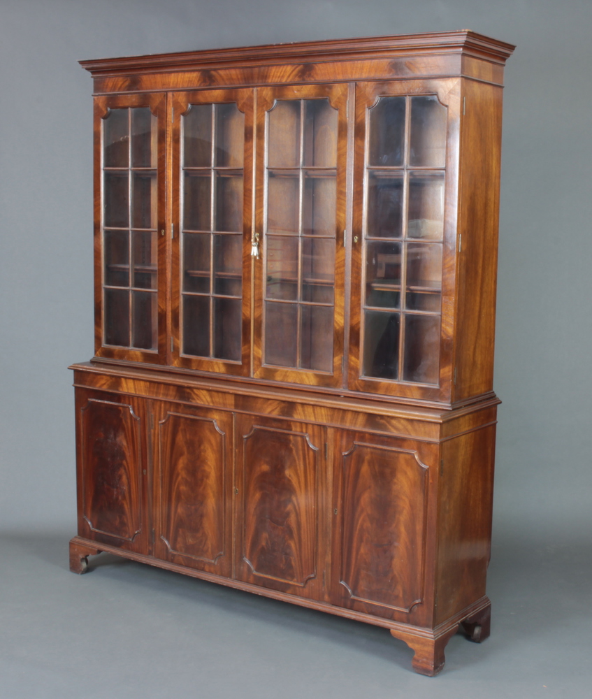 A Georgian style mahogany bookcase on cabinet, the upper section with moulded cornice fitted