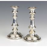 A pair of silver plated candlesticks with vase stems decorated with flowers 20cm