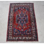 A Persian red and blue ground Behbahan rug with central medallion 202cm x 127cm The fringe is