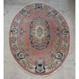 An oval pink ground and floral pattern Chinese rug 274cm x 199cm (fringe reduced)