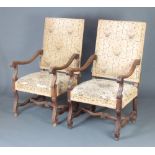 A pair of Italian style carved walnut open arm chairs, the seats and backs upholstered in