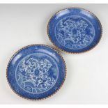 A pair of Chinese blue and white shallow dishes decorated with dragons amongst clouds 26cm