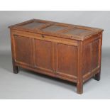 An 18th Century oak coffer of panelled construction with hinged lid, the interior fitted a candle