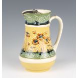 A MacIntyre Moorcroft jug decorated with flowers having a metal swing lid 17cm The lid is chipped in