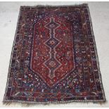 A tan and blue ground Qashqai carpet with stylised diamond medallion to the centre within a multi-
