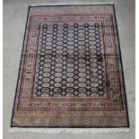 A blue ground Bokhara style Belgian cotton carpet with numerous octagons to the centre within a