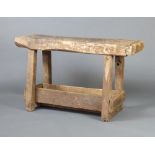 A 19th Century rustic rectangular weathered oak workbench raised on square supports with undertier
