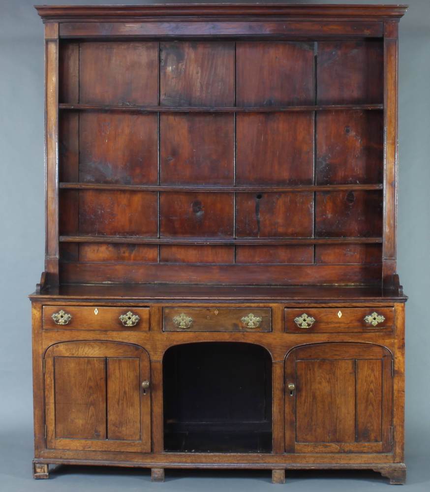 A Georgian oak dog kennel dresser, the raised back with moulded cornice fitted shelves, the base