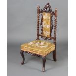 A Victorian Carolean style carved walnut nursing chair with spiral turned decoration, the seat and