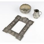 An Indian repousse silver rectangular frame decorated with deities together with a ditto cream jug