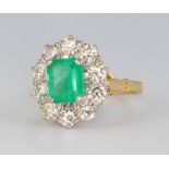 An 18ct yellow gold emerald and diamond cluster ring, the centre cut stone approx 1.35ct