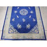 A 1930's Chinese blue and floral patterned carpet 540cm x 352cm There is a small section of moth