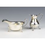 A silver sauce boat on pad feet Sheffield 1947 and a Georgian silver baluster cream jug 185 grams