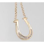 A 9ct yellow gold gem set horseshoe pendant and chain 48cm 3.5 grams gross