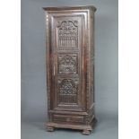 An 18th/19th Century Flemish carved black oak cabinet with moulded cornice and shelved interior, the