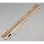 A 7' 2 piece split cane light spinning fishing rod in a brown cloth bag